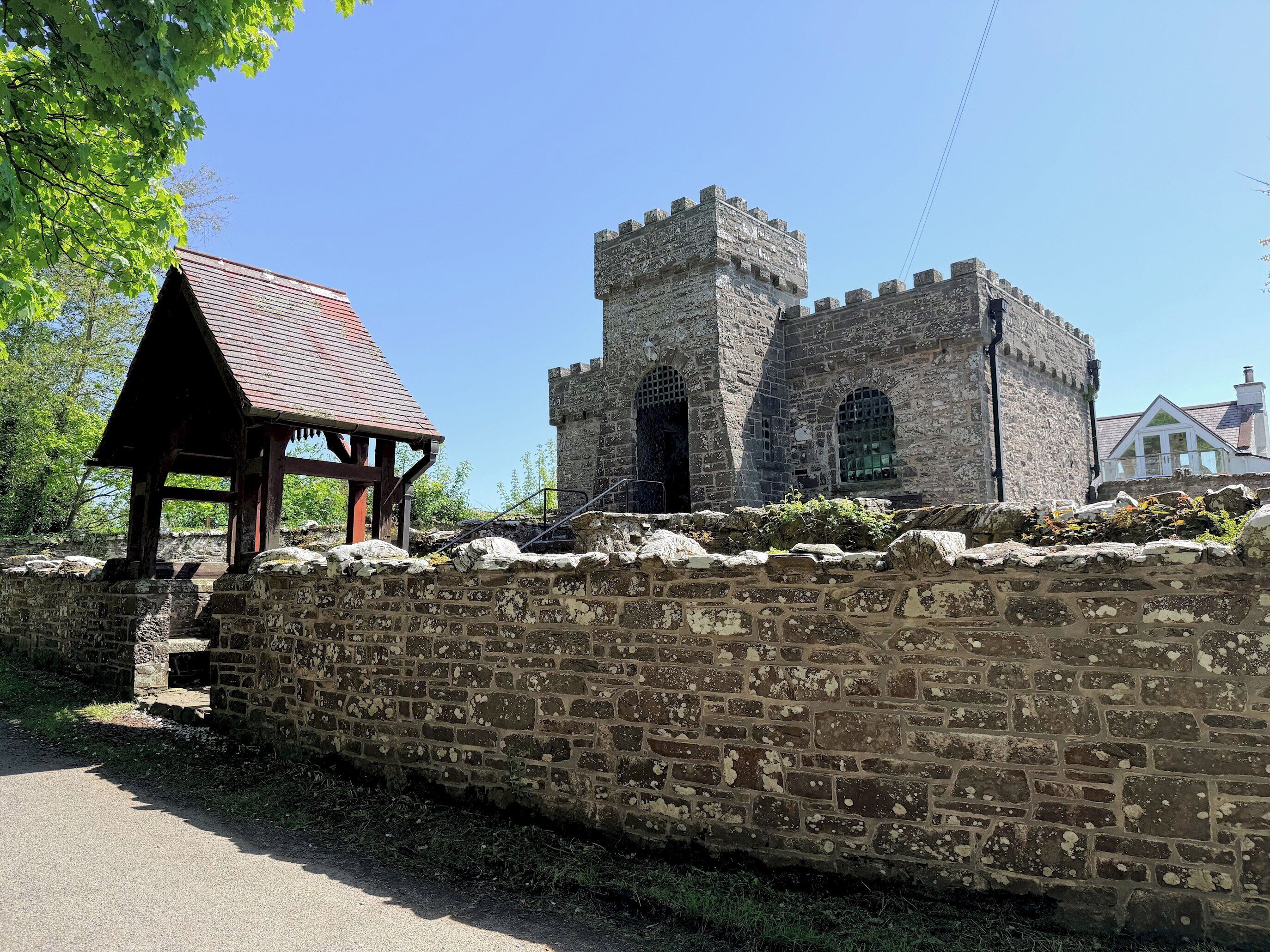 A stone wall, a wooden pavilion, and a castle-like structure.