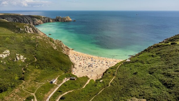 En kyststrækning med kig til havet og en sti ned til stranden.