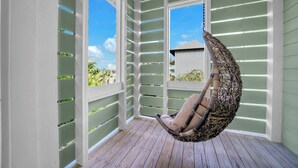A room with a hanging chair, large windows, and a wooden floor. - Close to Trails and Lakes with Shared Pool (Santa Rosa Beach)
