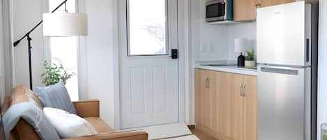 Una cocina moderna con refrigerador, microondas y armarios de madera.