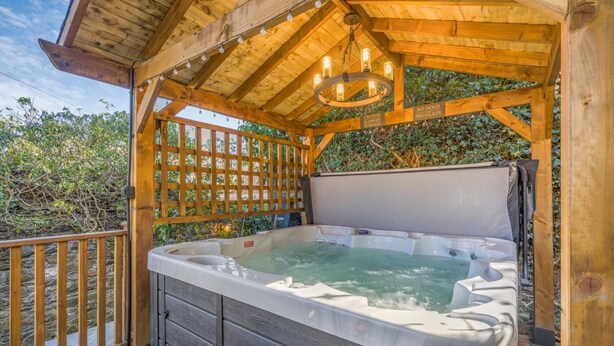 A wooden hot tub with a wooden deck and a pergola overhead. - 1 Bed in Banff (oc-t42474) (Banff)