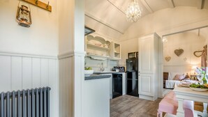 A kitchen with white cabinetry, a black refrigerator, and a wooden countertop. - 1 Bed in Near Boscastle (oc-f42575) (Forrabury and Minster)