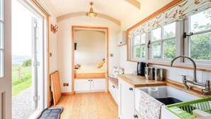A compact kitchen with a built-in bench, a sink, and a window with a view.