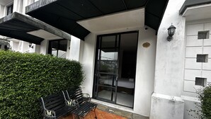 A building entrance with a bench, a hedge, and a tiled patio. - Townhouse Oak Casa D'Ladera Bandung (Bandung)