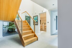 Ein modernes Interieur mit einer Holztreppe, einer Küchenzeile und einem Essbereich.