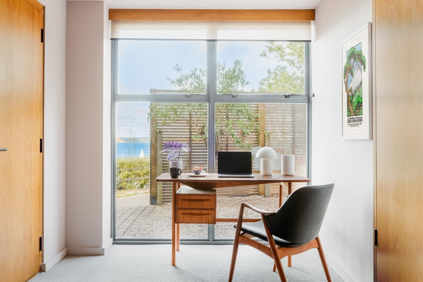 Une chambre moderne équipée d’un bureau, d’une chaise et offrant une vue sur l’extérieur.