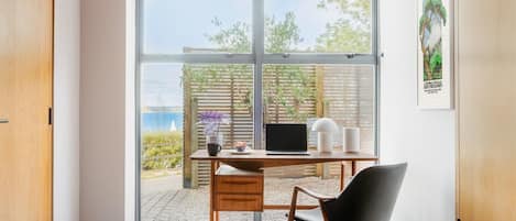A modern room with a desk, chair, and a view of the outdoors.