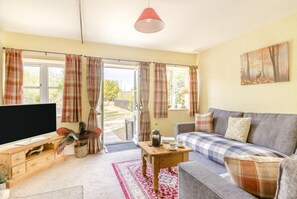 A living room with a sofa, a television, a coffee table, and a window with curtains. - 2 Bed in Westport (oc-c42687) (Westport)