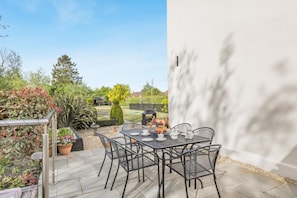 An outdoor patio with a table and chairs, surrounded by potted plants and a view of the garden. - 2 Bed in Westport (oc-c42687) (Westport)