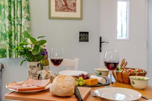A dining table with food, wine glasses, a loaf of bread, and a vase of flowers. - 1 Bed in Buckland Filleigh (oc-h41749) (Buckland Filleigh)