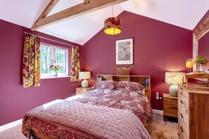 A bedroom with a bed, a window with curtains, a bedside table with a lamp, and a dresser with a mirror. - 1 Bed in Buckland Filleigh (oc-h41749) (Buckland Filleigh)