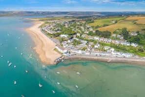 An aerial view of a coastal town with a sandy beach, a marina with boats, and residential buildings. - 1 Bed in Buckland Filleigh (oc-h41749) (Buckland Filleigh)
