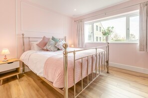 A bedroom with a bed, bedside table, and a window with curtains. - 1 Bed in Harris Mill (oc-l42584) (Redruth)