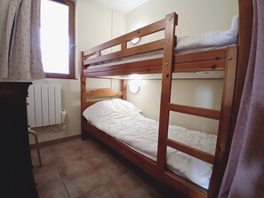 A bunk bed room with a radiator, a window with curtains, and a wooden desk. - Apartment for 4 People in Val Cenis (Val-Cenis)