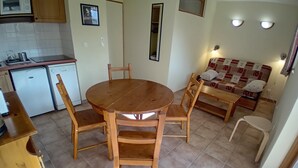 A compact kitchen with a dining table and chairs, a sofa, and a small refrigerator. - Apartment for 4 People in Val Cenis (Val-Cenis)