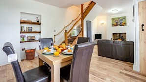 A dining area with a wooden table, chairs, and breakfast items. A staircase with a wooden railing leads to another room. - 2 Bed in Consett (oc-b42654) (Consett)