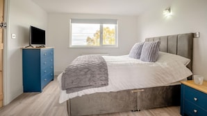 A bedroom with a bed, a TV on a stand, a window, and a bedside table. - 2 Bed in Consett (oc-b42654) (Consett)