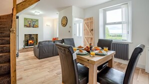 A cozy living area with a fireplace, a dining table set with breakfast, and a view of the outdoors. - 2 Bed in Consett (oc-b42654) (Consett)