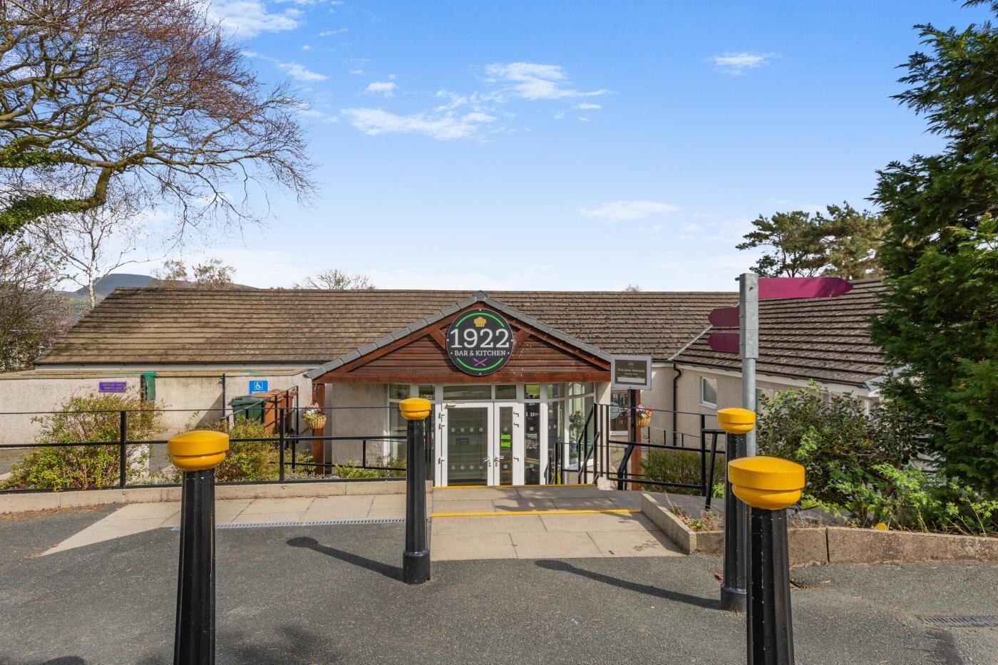 Un bâtiment dont l’entrée est marquée par une enseigne indiquant « 1922 BAR & KITCHEN ».