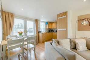 A modern living room with a sofa and a dining area with a table and chairs. - 2 Bed in Seahouses (oc-s42665) (Seahouses)