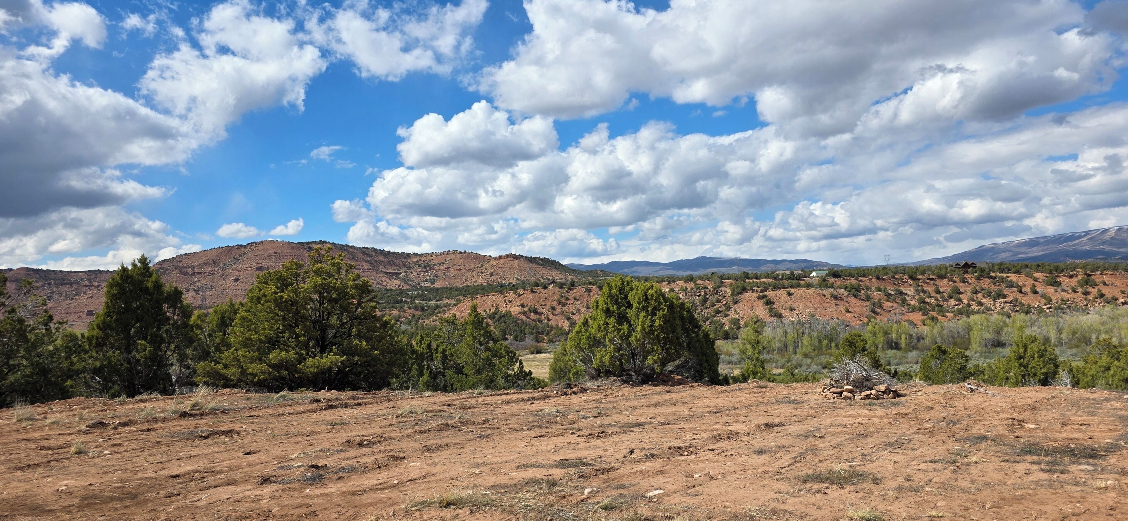 A mountainous landscape with sparse vegetation and a clear sky.