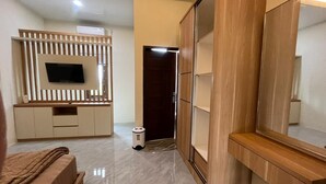 A modern bedroom with a TV, wardrobe, and a bed.