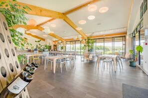 A spacious dining area with wooden beams, large windows, and potted plants. - 1 Bed in St. Issey (oc-w42638) (Saint Issey)