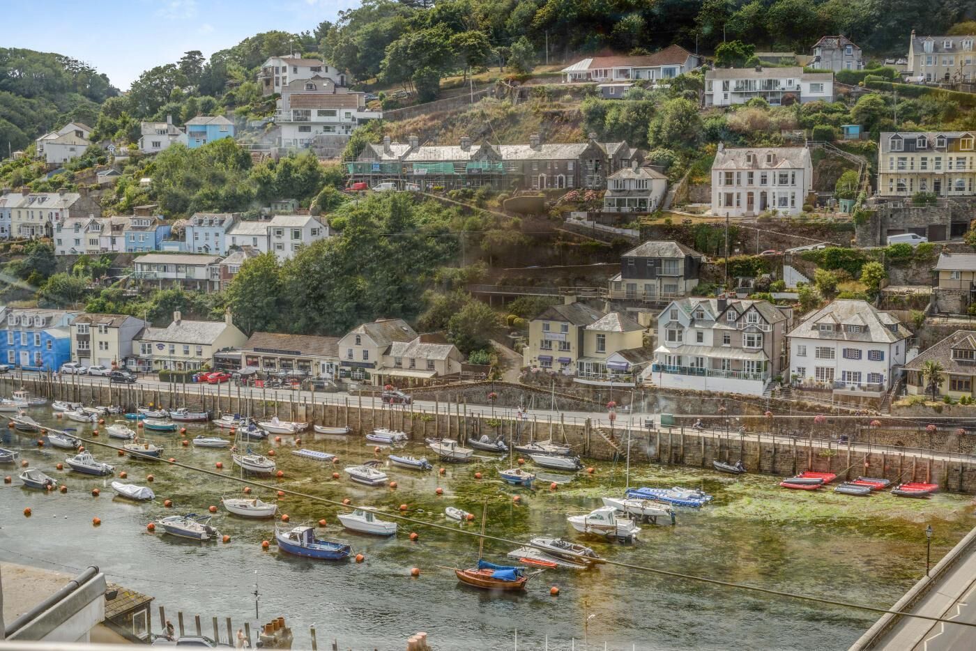 A coastal town with a marina filled with boats, surrounded by residential buildings.