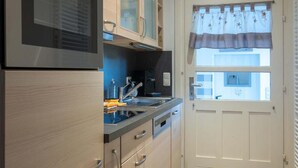 Une cuisine équipée d’un four à micro-ondes, d’un four traditionnel et de placards.