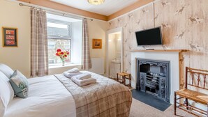 A hotel room with a bed, a fireplace, a television, and a window with curtains. - 3 Bed in Reeth (oc-b42655) (Reeth)