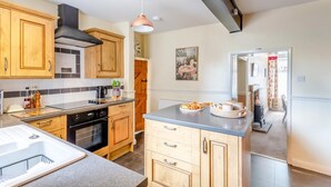 A kitchen with wooden cabinets, a stove, and a sink. - 3 Bed in Reeth (oc-b42655) (Reeth)