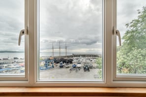 A view through a window of a marina with boats, a large ship, and a cloudy sky. - 3 Bed in Saundersfoot (oc-m42704) (Saundersfoot)