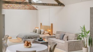 A modern, well-lit room with a bed, sofa, dining table, and chairs. - 1 Bed in Gembling (oc-s42456) (Gembling)