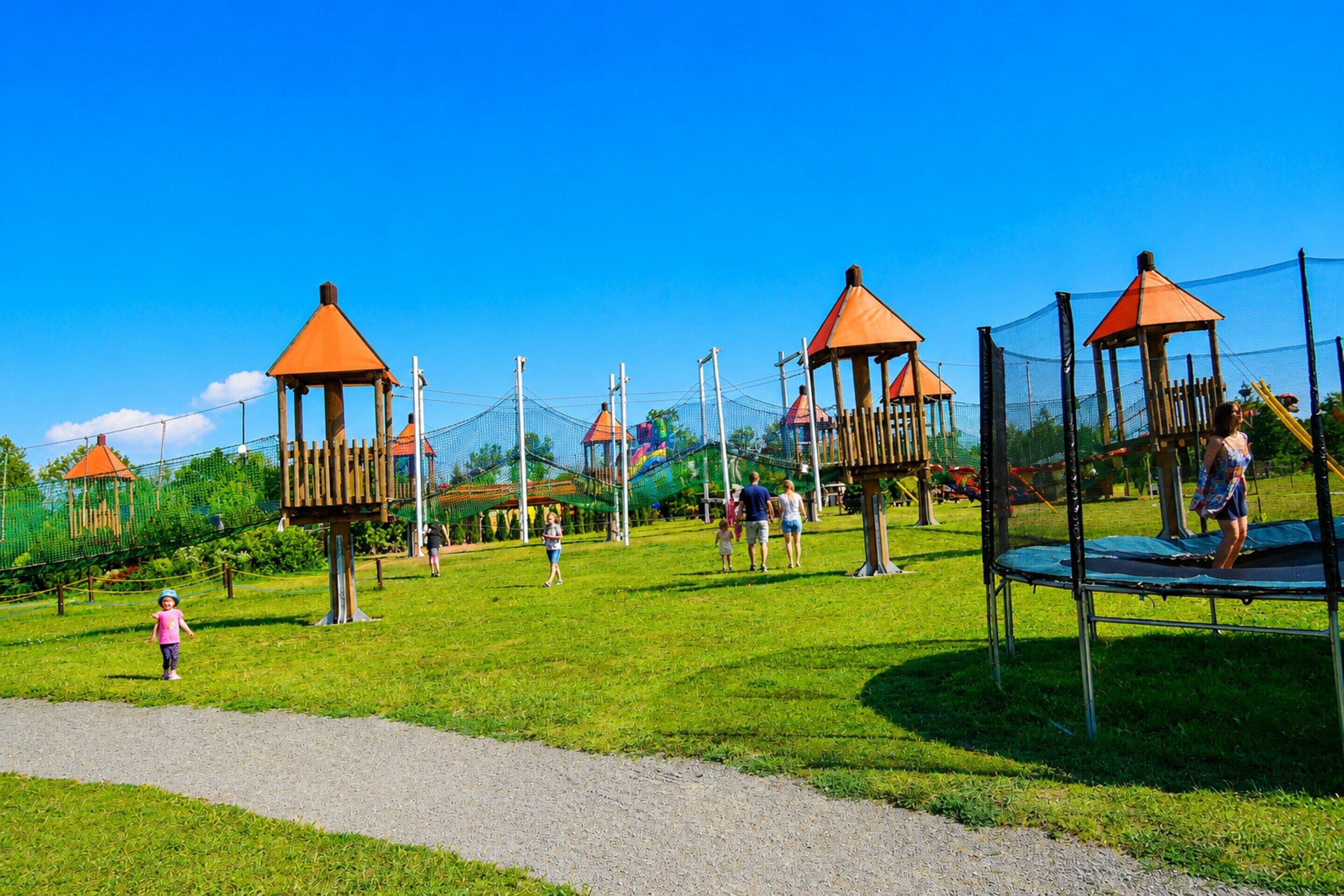 A playground with multiple play structures, including a swing set and climbing frames.
