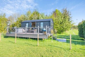 A modern, single-story house with a deck, surrounded by a fenced yard and trees. - 1 Bed in Newall With Clifton (oc-t42700) (Newall With Clifton)
