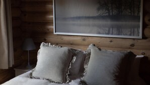 A wooden cabin-style room with a bed, pillows, a lamp, and a framed picture of a forest scene. - 2 Bed in Cretingham (oc-m42623) (Cretingham)