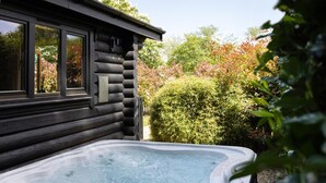 A log cabin with a hot tub in front. - 2 Bed in Cretingham (oc-m42623) (Cretingham)