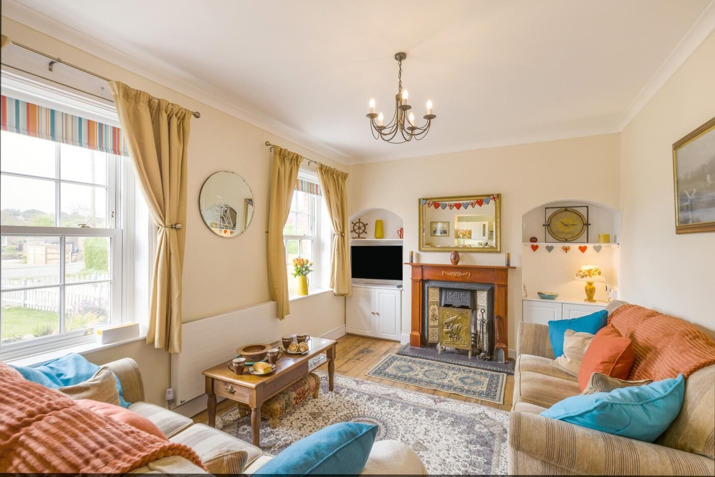 A cozy living room with a fireplace, a television, and a comfortable sofa.