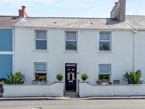 A two-story residential building with a black front door, white walls, and multiple windows. - 3 Bed in Tenby (oc-fb189) (Tenby)