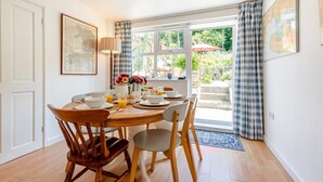 Un comedor con una mesa lista para el desayuno, una lámpara y vistas al exterior.