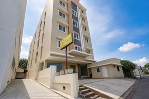 A multi-story hotel with a prominent sign, a staircase leading to the entrance, and a clear sky. - Townhouse Oak Hotel Niaga Surabaya (Surabaya)