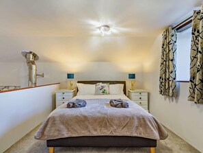 A bedroom with a bed, two bedside tables, a nightstand, a ceiling light, and a window with curtains. - 1 Bed in Barnstaple (oc-norwo) (Hiscott)