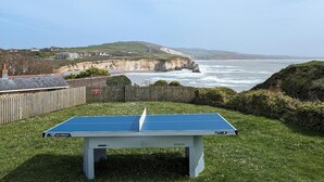 A ping pong table in a grassy area with a coastal view. - 3 Bed in Freshwater (oc-78098) (Freshwater)