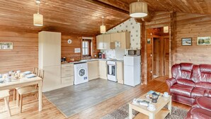 A cozy cabin interior with a dining area, kitchen, and seating space.