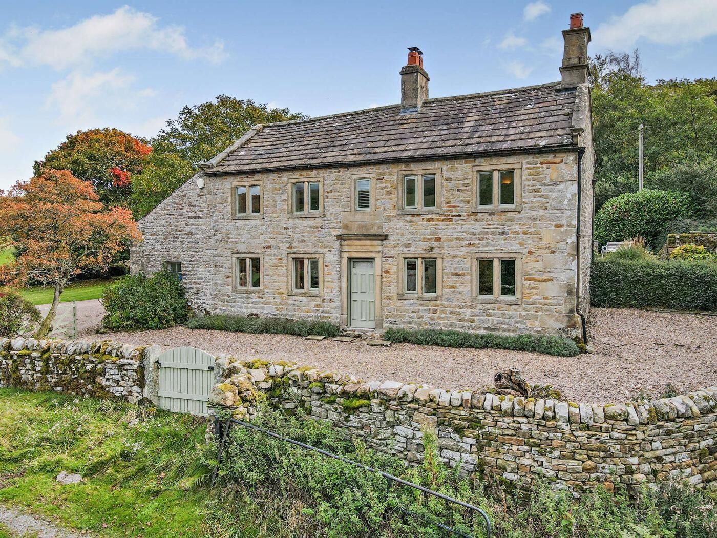 A stone house with a traditional design, featuring a central door and multiple windows.