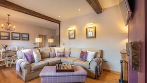A living room with a sectional sofa, a plaid ottoman, and a chessboard. - 1 Bed in Brecon (oc-42942) (Llanfrynach)