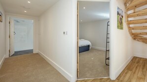 Una habitación con una cama, una escalera y una puerta que da a otra estancia.