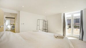 A bedroom with a large bed, a ladder, and a sliding glass door to an outdoor area. - 1 Bed in Barrow (oc-b42641) (Barrow)