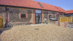 A stone building with a red-tiled roof, a glass door, and a gravel driveway. - 1 Bed in Barrow (oc-b42641) (Barrow)
