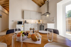 A modern kitchen with white cabinets, a microwave, and a stove. - 2 Bed in Barrow (oc-b42642) (Barrow)